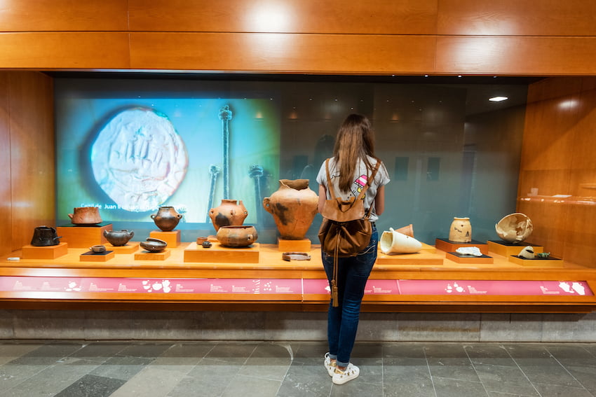 Femme admirant l'intérieur du musée et du parc archéologique 