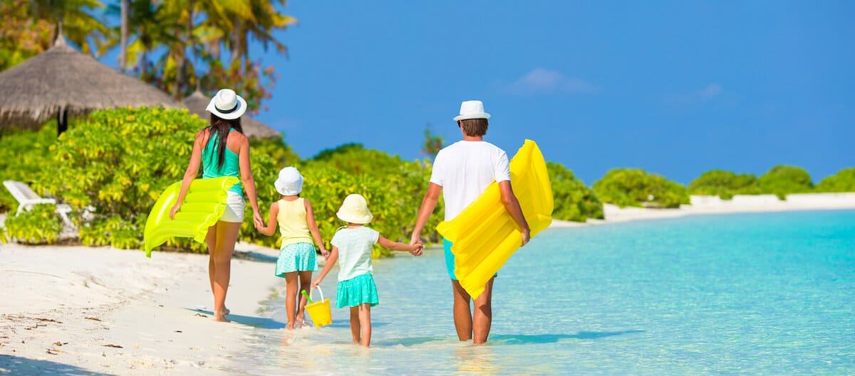 Famille en vacances sur une plage des Caraibes grâce à l'offre Cdiscount Voyages.