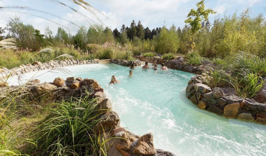 Des personnes se baignent dans la rivière douce du domaine des 3 forêts.