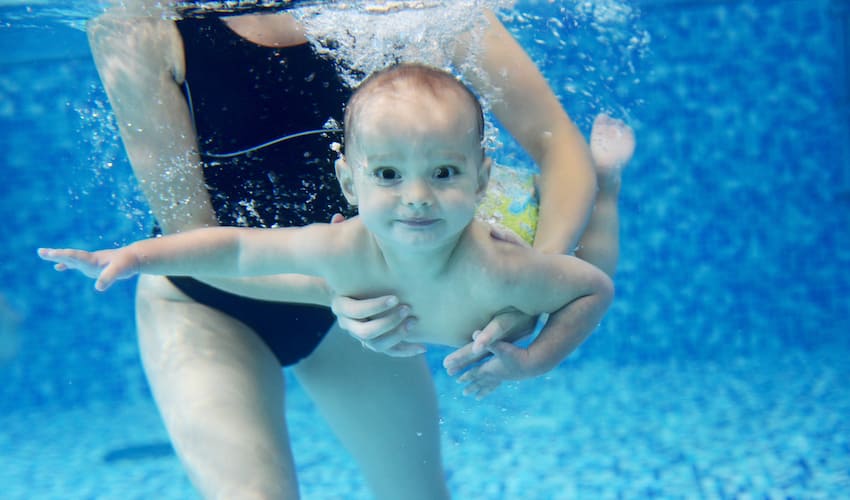 Bébé nageyur tenu par sa mère
