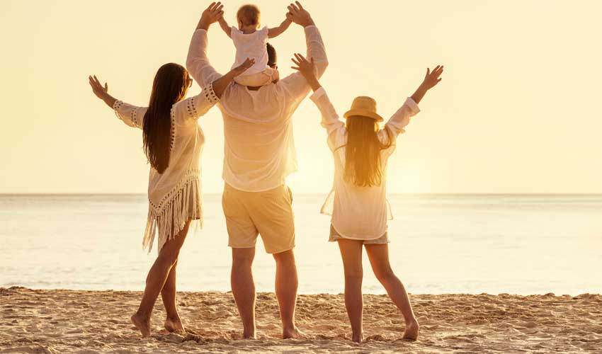 Famille heureuse profitant du coucher du soleil à la plage