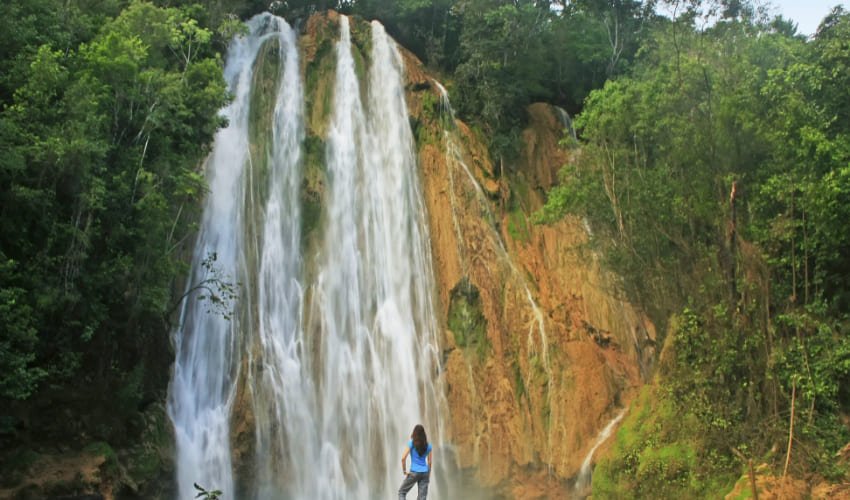 Une jeune femme admire la cascade el Limon en République Dominicaine.