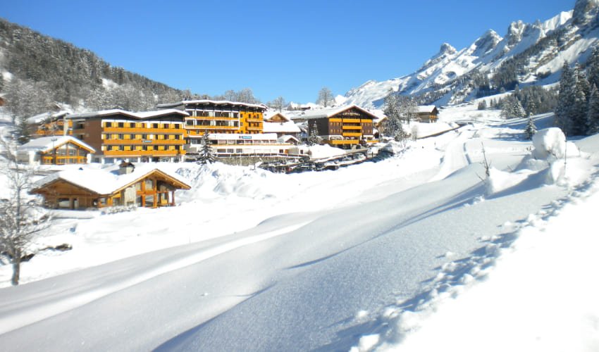 Club Montagne Azureva de La Clusaz sous la neige par ciel bleu.