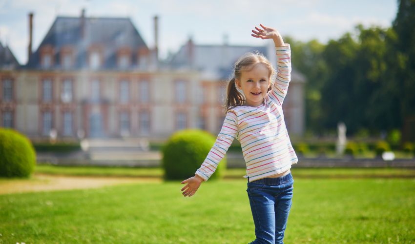Une petite fille pose dans le parc du Château de Breteuil