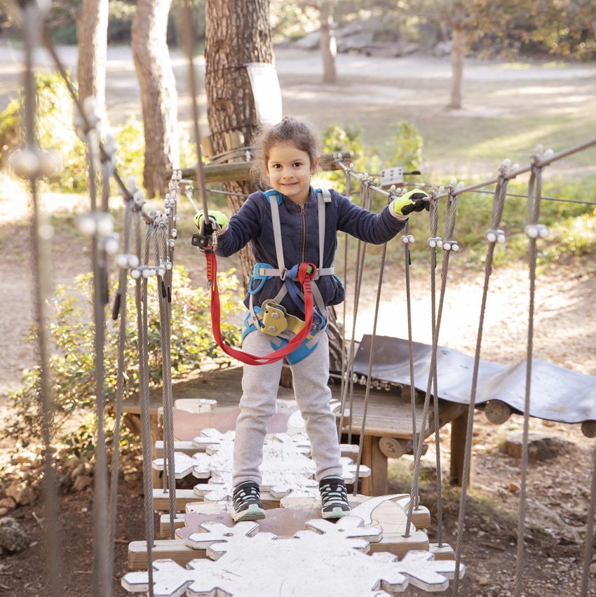 Petite fille sur un parcours accrobranche